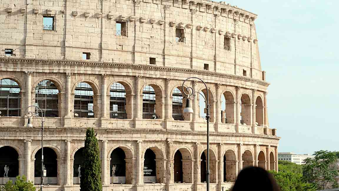 Billede af Colosseum i Rom, Italien, med en kvinde i forgrunden. (AI-genereret tekst)