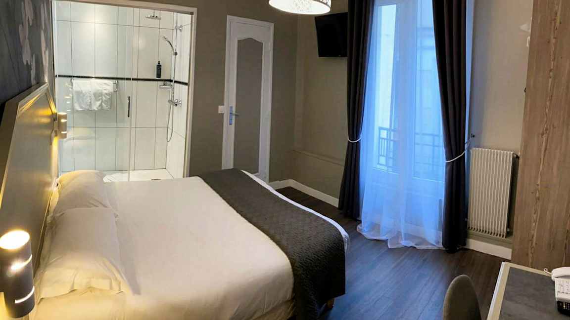 Et hotelværelse med en seng, et skrivebord og en bruser. (AI-genereret tekst)