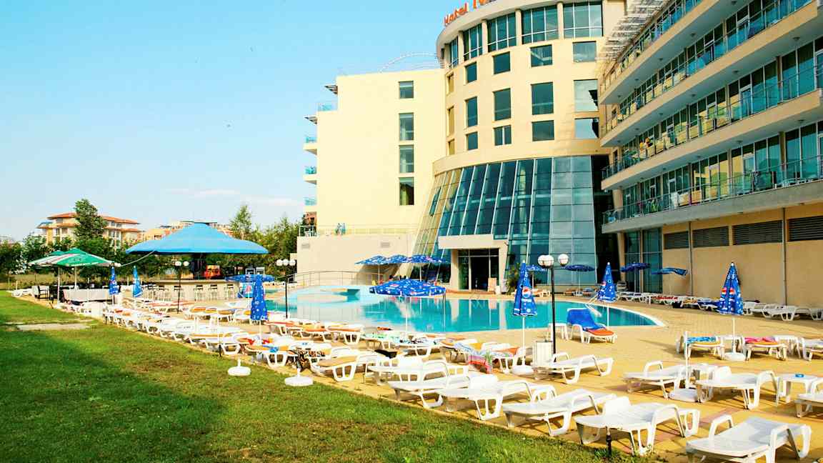 Hotellets poolområde med liggestole og parasoller. (AI-genereret tekst)