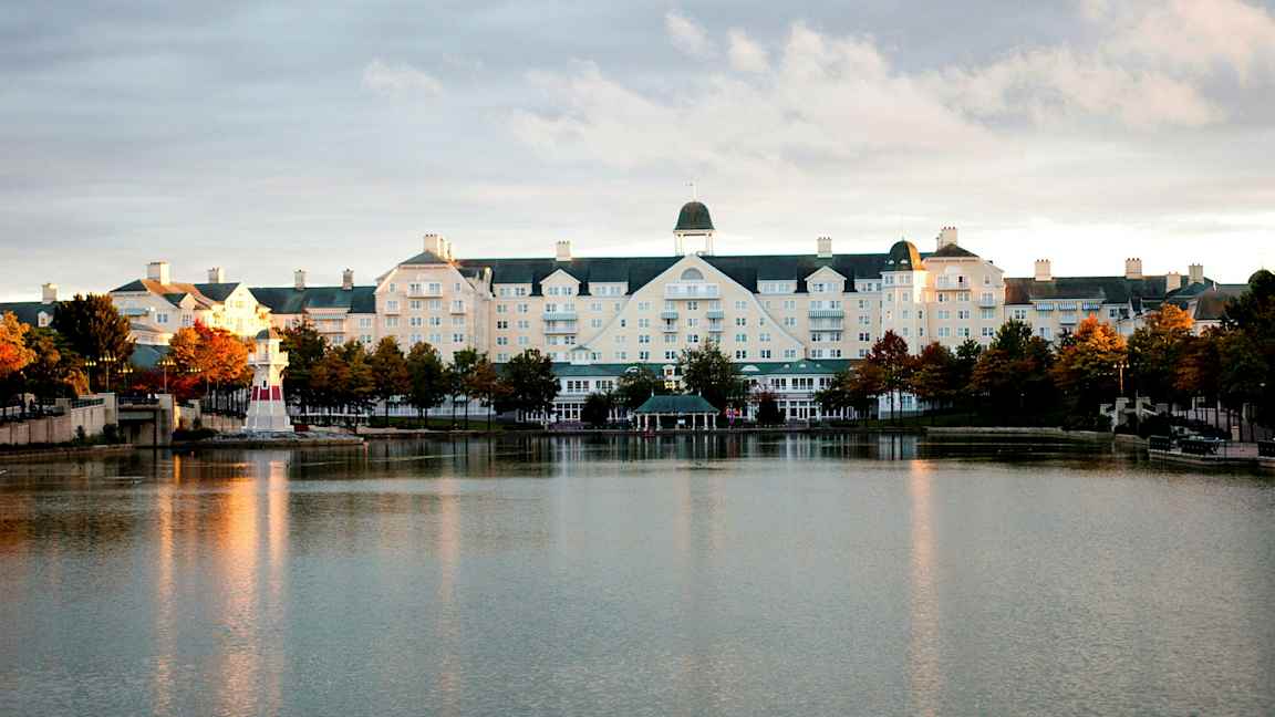 Hotelbygning ved en sø med et lille fyrtårn. (AI-genereret tekst)