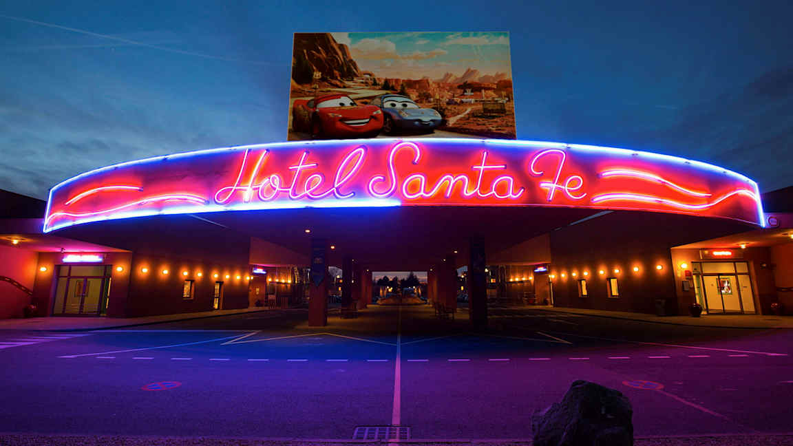 Neonskiltet over indgangen til Hotel Santa Fe med Disney/Pixar-biler på plakaten ovenover. (AI-genereret tekst)