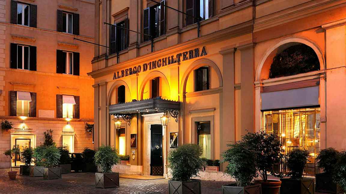 Et hotel med en arkade foran indgangen, oplyst om aftenen. (AI-genereret tekst)