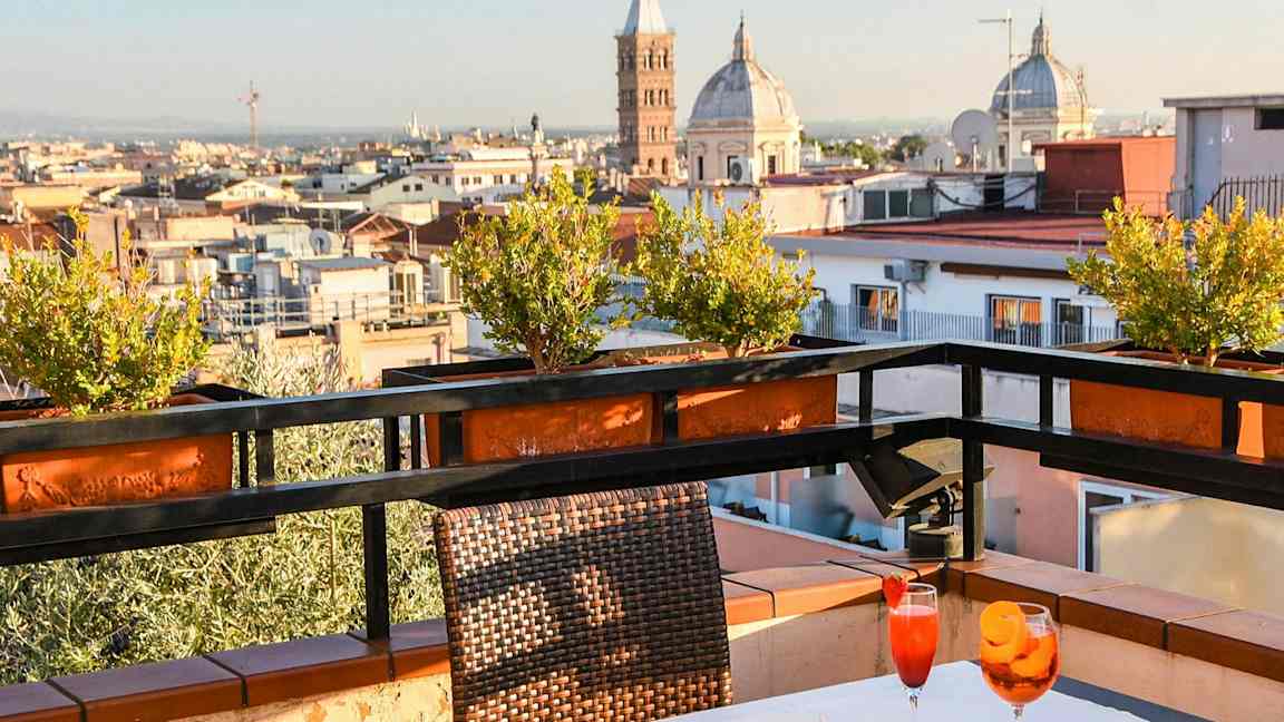 En terrasse med bord, stole og udsigt over byen med kirkespir. (AI-genereret tekst)