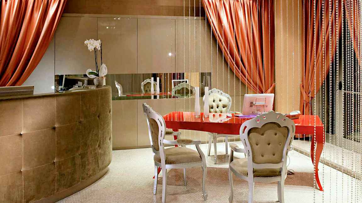 Et indbydende rum med et rødt bord, elegante møbler og dekorative elementer. (AI-genereret tekst)