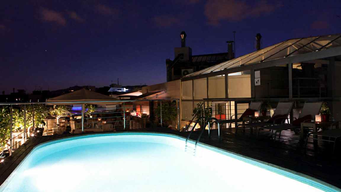 Oplyst pool på en tagterrasse ved skumring. (AI-genereret tekst)