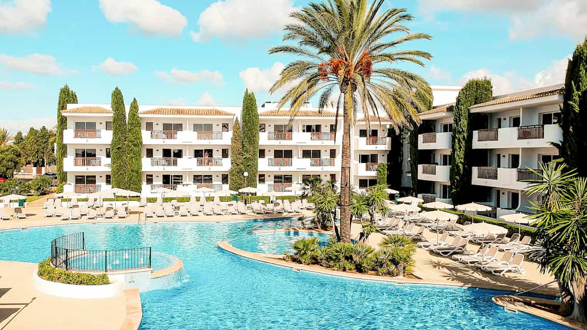 Billede af hotelområde med swimmingpool og liggestole. (AI-genereret tekst)