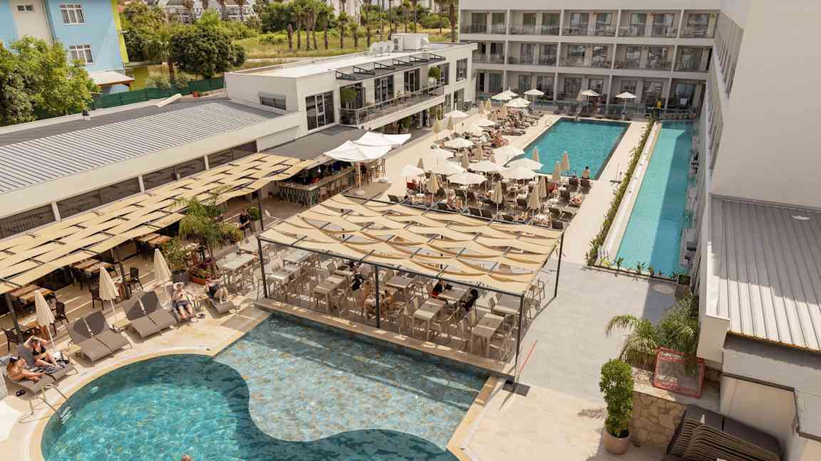 Hotellets poolområde med liggestole, parasoller og servering ved poolen. (AI-genereret tekst)