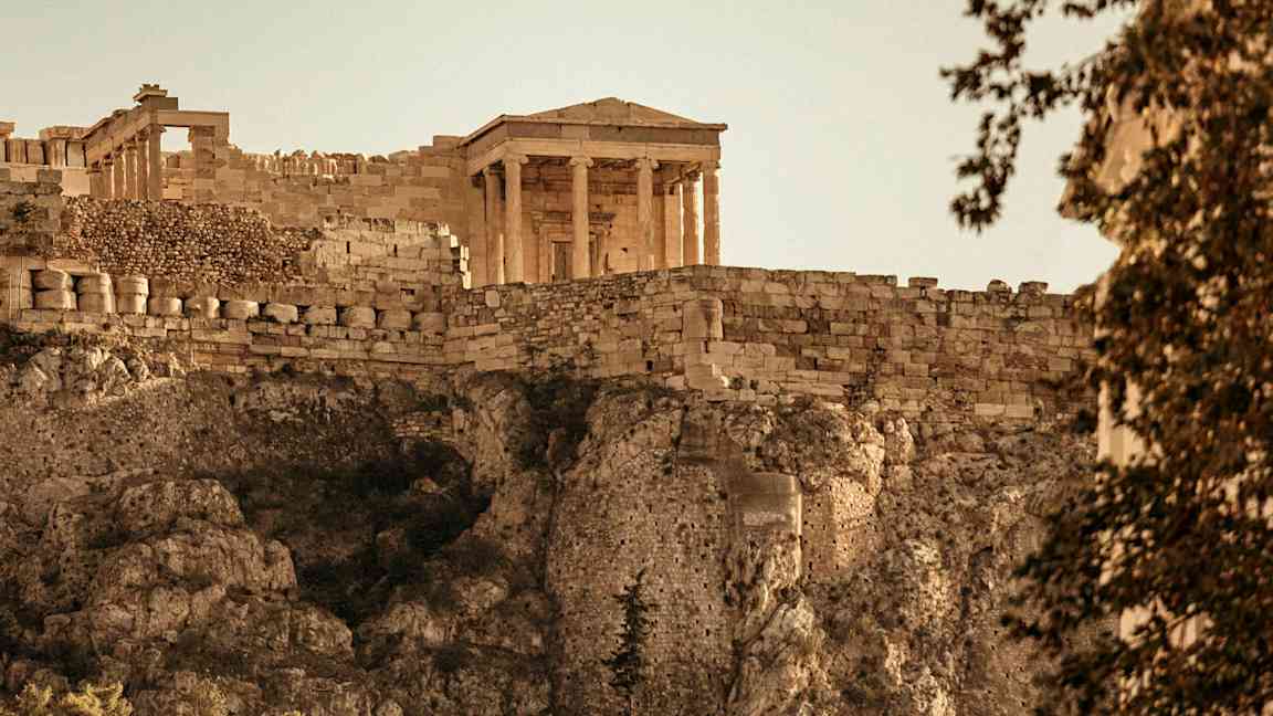 Et antikt tempel på Akropolis med stenmur og klipper. (AI-genereret tekst)