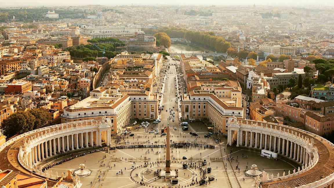 Udsigt over Peterspladsen i Vatikanstaten, omgivet af bygninger og pilgrimsrejser. (AI-genereret tekst)