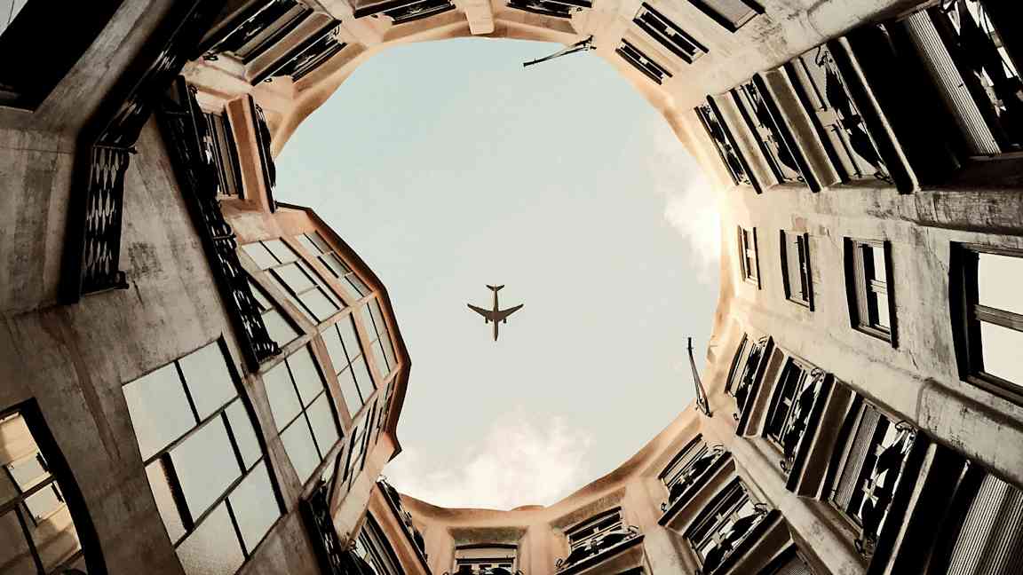 Et billede af en flysilhuet mod himlen set fra gården af en bygning. (AI-genereret tekst)