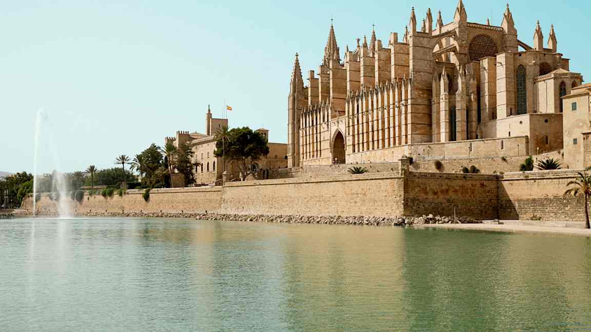 En katedral ved vandet med en fontæne i forgrunden. (AI-genereret tekst)