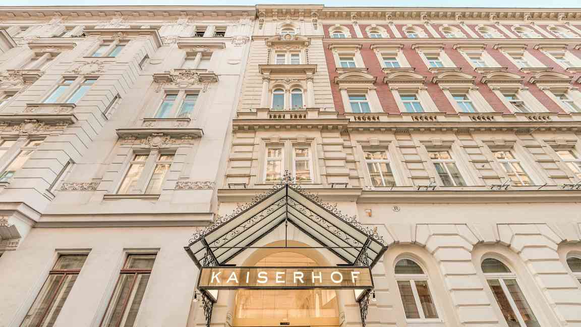 Bygningens facade med inskriptionen 'Kaiserhof' ved indgangen. (AI-genereret tekst)