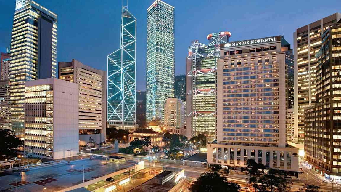 Byudsigt med høje bygninger oplyst i aftenlys. (AI-genereret tekst)