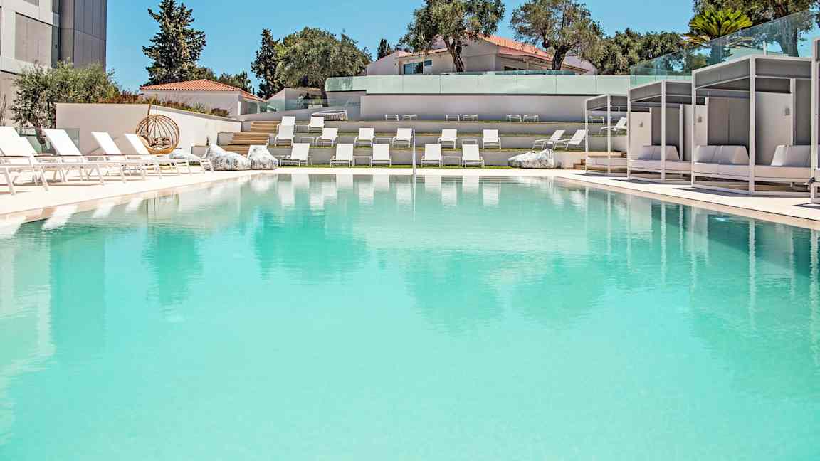 Eksklusiv udendørs pool omgivet af liggestole og moderne skyggeområder. (AI-genereret tekst)