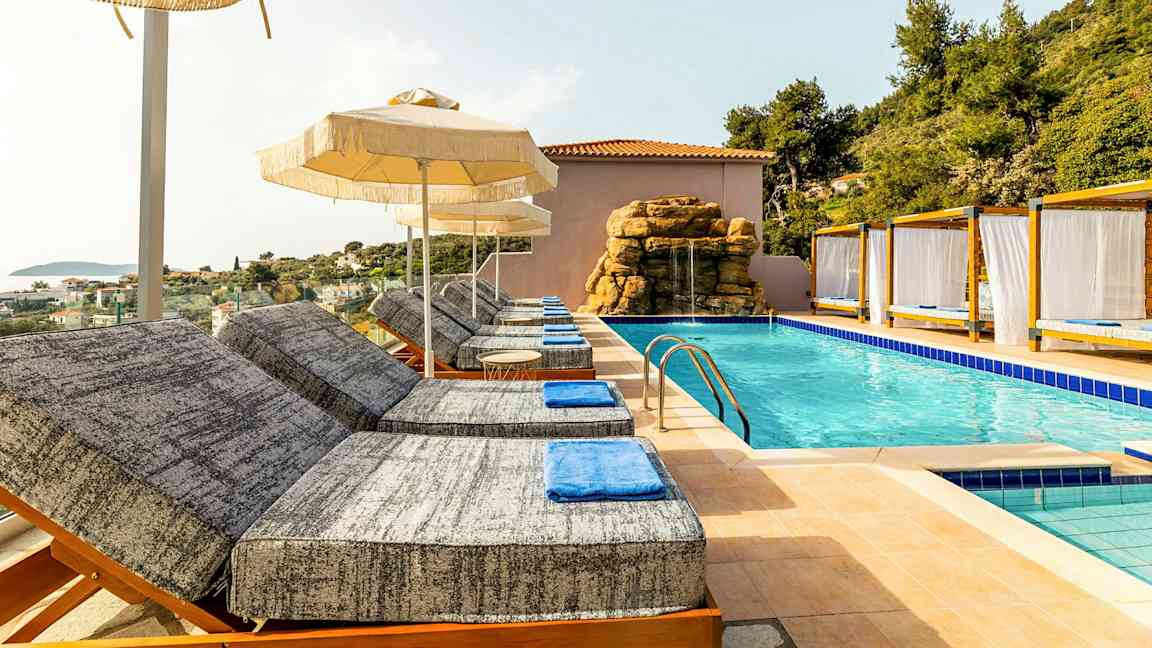 Solstole ved en pool med parasoller og cabanas. (AI-genereret tekst)