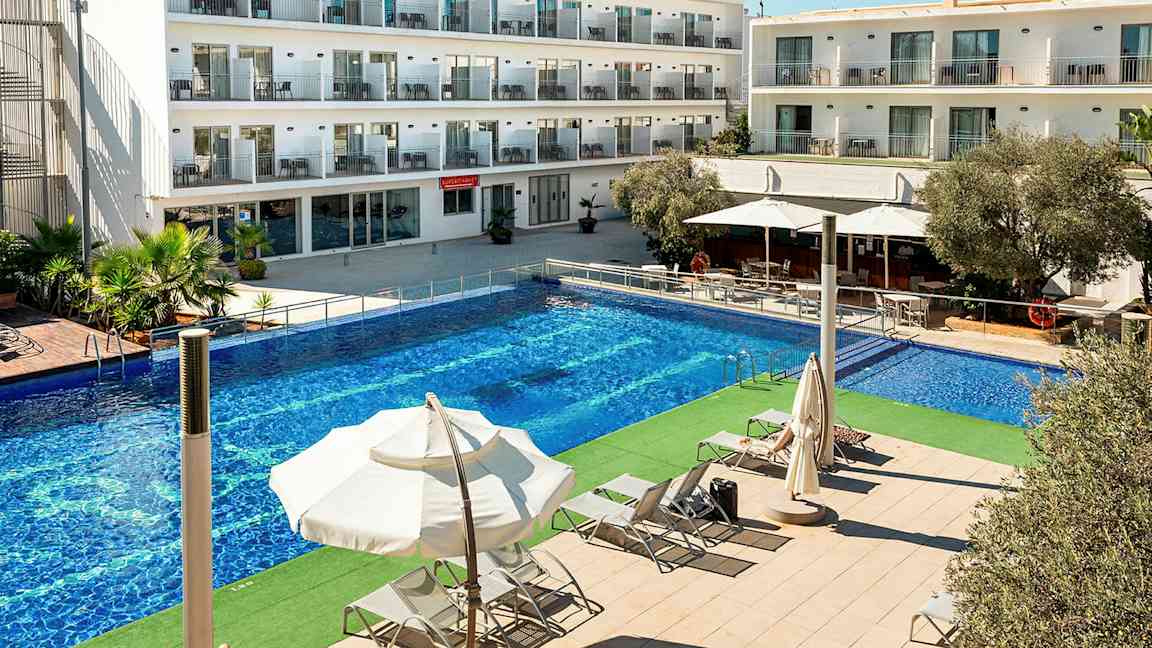 Billede af en hotelbygning med flere etager. Foran bygningen er der en stor pool og liggestole under parasoller. (AI-genereret tekst)