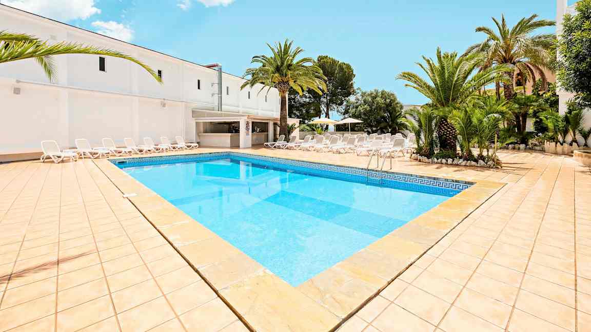 Billede, der viser en swimmingpool med lyseblåt vand, omgivet af en solterrasse med liggestole og palmer. (AI-genereret tekst)