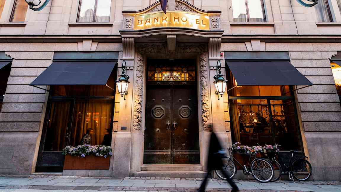 Bygningsfacade med indgangen til Bank Hotel, tydelige detaljer og belysning. (AI-genereret tekst)