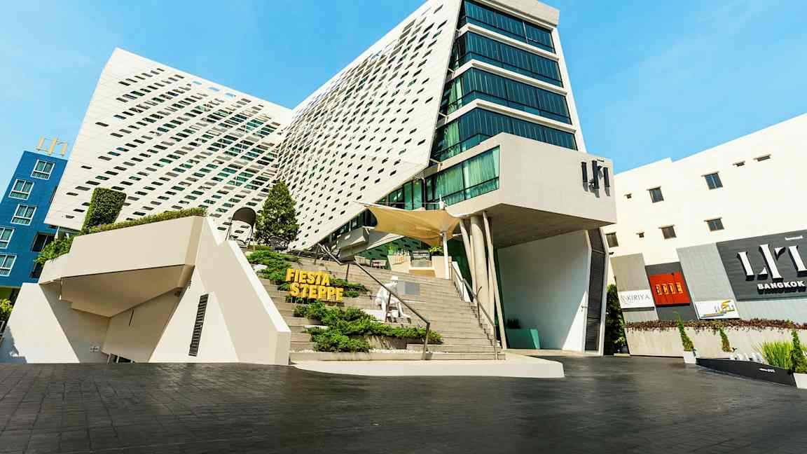 Moderne bygning med unik arkitektur, store glaspartier og en skrå facade. (AI-genereret tekst)