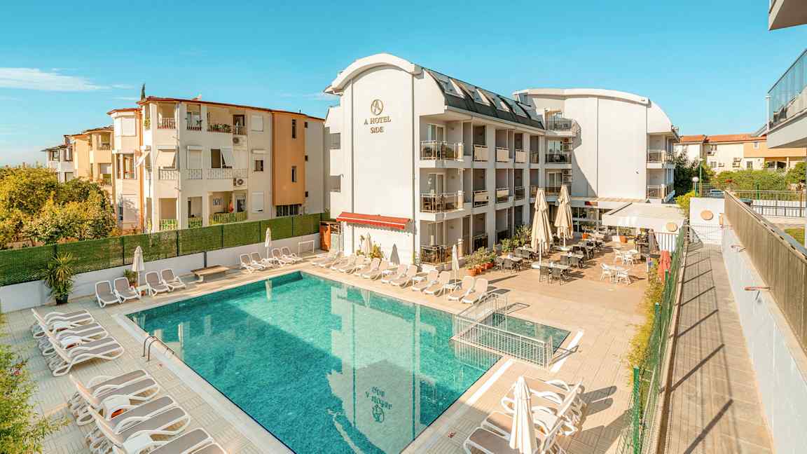 En bygning med hotelfaciliteter ved en udendørs pool. (AI-genereret tekst)