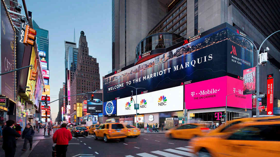 Et livligt bybillede med skyskrabere, neonskilte og gule taxaer, med en reklameplakat for Marriott Marquis. (AI-genereret tekst)