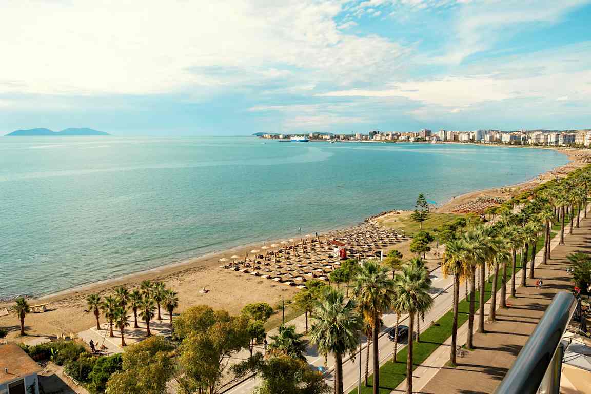 Strand med parasoller og havet i baggrunden. (AI-genereret tekst)