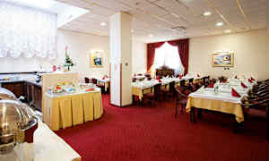 Interiør af en spisesal med dækkede borde, røde gardiner og en buffet. (AI-genereret tekst)