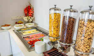 En morgenbuffet med skåle med morgenmadsprodukter, æg, frugt og pålæg. (AI-genereret tekst)