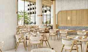 Restaurantmiljø med moderne borde og stole, store vinduer der lader naturligt lys komme ind, og palmer udenfor. (AI-genereret tekst)