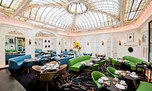 En restaurant med dekorativt glastag og farverige møbler. (AI-genereret tekst)