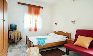 Billede af et hotelværelse med enkeltseng, rød sofa og små møbler. (AI-genereret tekst)