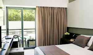 Hotelværelse med dobbeltseng og balkon med siddeplads. (AI-genereret tekst)