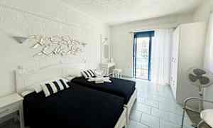 Værelse med to enkeltsenge, hvidt interiør og en altan med havudsigt. (AI-genereret tekst)