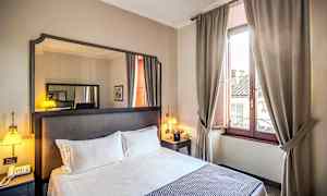 Hotelværelse med dobbeltseng, natbord, spejl og vindue med beige gardiner. (AI-genereret tekst)