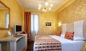 Et hotelværelse med en dobbeltseng, skrivebord med en TV og stol, og dekorative elementer. (AI-genereret tekst)