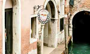 Indgang til et hotel ved en kanal i Venedig. (AI-genereret tekst)