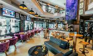 En indbydende bar med moderne møbler og dekorative elementer såsom kunstværker og skulpturer. (AI-genereret tekst)