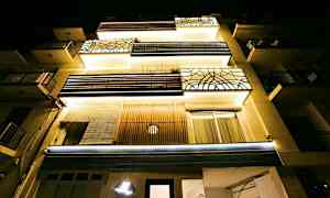 Lejlighedsbygning set nedefra med natbelysning. (AI-genereret tekst)