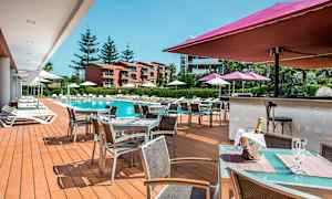 Udendørsområde med pool, liggestole og et serveringsområde. (AI-genereret tekst)