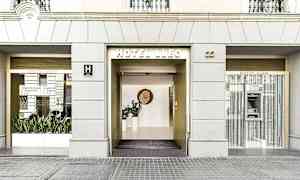 Billede af Hotel Lleos indgang med store glaspartier og en moderne indgang. (AI-genereret tekst)