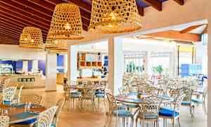 Lys og luftig restaurant med elegant møblement og store kurvelamper. (AI-genereret tekst)