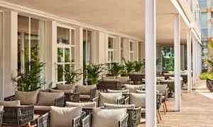 Udendørs område med siddegrupper og beplantning. (AI-genereret tekst)