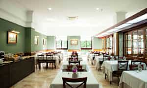 Indretning af en restaurant med dækkede borde og stole. (AI-genereret tekst)