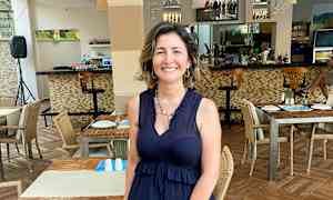 Restaurant med opstillet borde og stole samt en bardisk i baggrunden. (AI-genereret tekst)