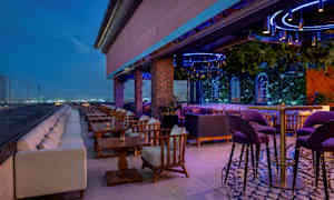 En tagterrasse med udendørs møbler og belysning. (AI-genereret tekst)