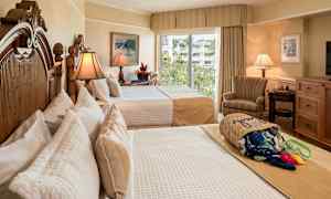 Hotelværelse med to senge, elegant indretning og lysindfald fra et vindue med udsigt over grønne områder. (AI-genereret tekst)