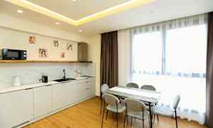 Et moderne køkken og spiseområde med lyse møbler og store vinduer. (AI-genereret tekst)