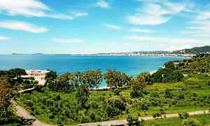 Udsigt over en kystby med hav og grønt. (AI-genereret tekst)