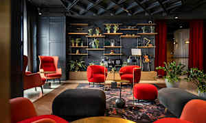 Elegant lounge med røde og sorte møbler, planter og en hylde med dekorative genstande. (AI-genereret tekst)