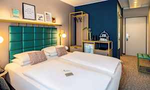 Hotelværelse med en dobbeltseng, moderne indretning og et garderobeskab med bøjler. (AI-genereret tekst)